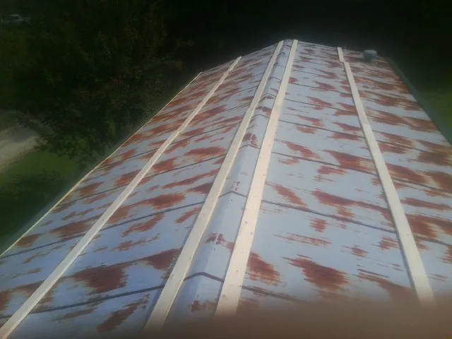 Rusted metal roof panels with new wood purlins before replacement — Storm Damage Roof Repair in Winfield by Roofing Brothers